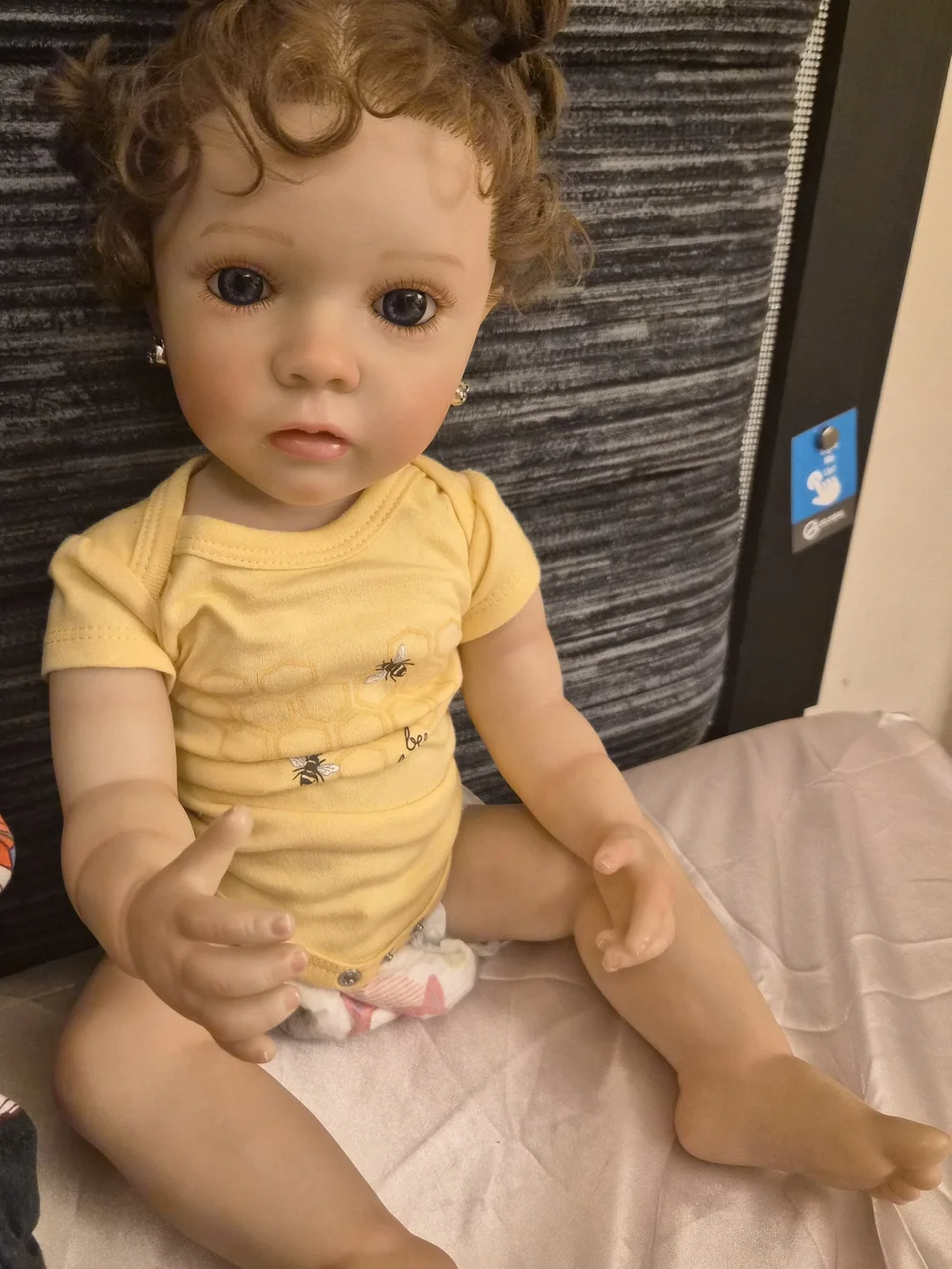 Reborn Baby Doll in Yellow Onesie with Curly Brown Hair